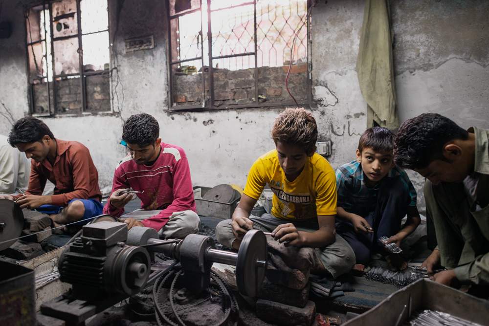 Children at work in an unregulated workshop making surgical tools